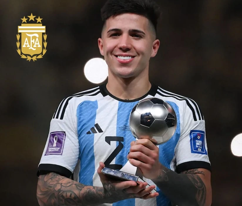 Enzo Fernandez holds a trophy shaped like a small soccer ball. The AFA logo is displayed on the left.